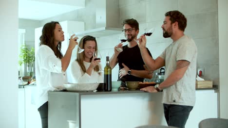 Cheerful-friends-clinking-glasses-with-red-wine